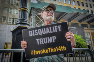 trump 14th amendment Participant seen holding a sign outside Trump Tower. Members